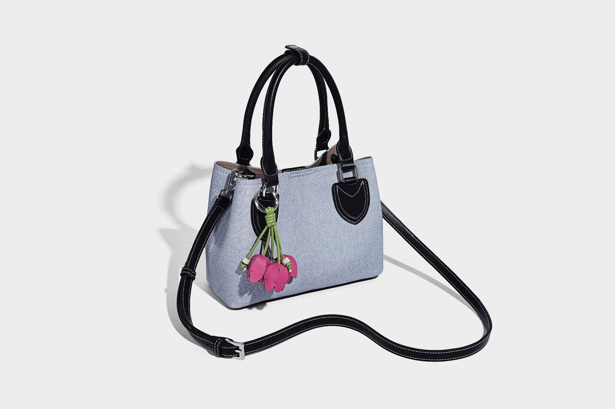 Structured light-blue denim-look tote bag with black leather-look handles, white contrast stitching, silver-tone hardware