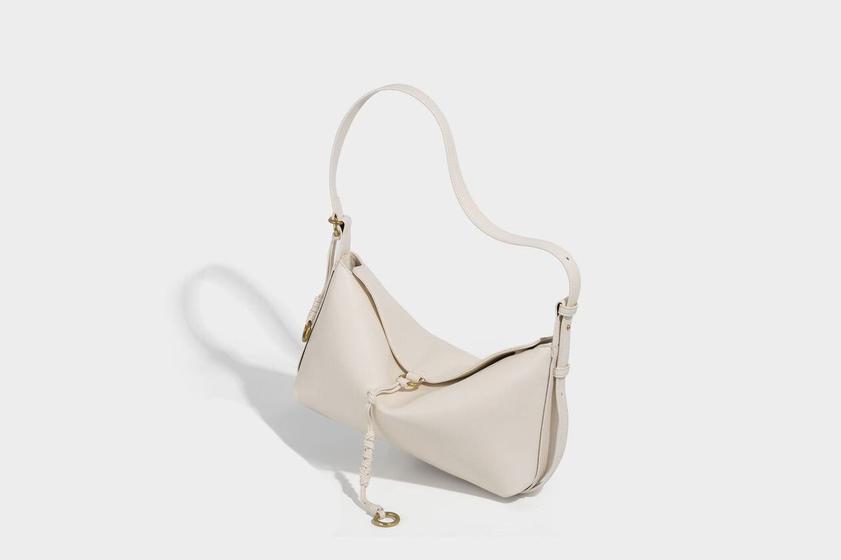 Slouchy brown leather-look shoulder bag with knotted drawcord tie closure, gold-tone ring hardware, and long adjustable