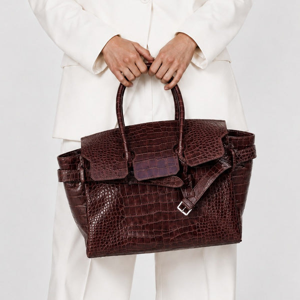 Large structured tote satchel with glossy crocodile-embossed leather-look finish, dual top handles, and metal buckle flap