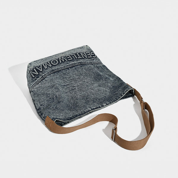 Washed blue denim slouchy open-top shoulder tote bag with tan leather-look adjustable crossbody strap and embroidered, detail