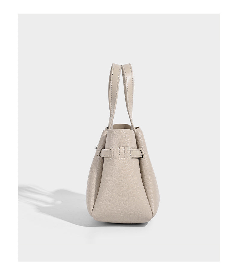 Small structured pebbled bucket tote with double top handles, silver turn-lock hardware, and detachable shoulder strap