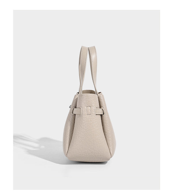 Small structured pebbled bucket tote with double top handles, silver turn-lock hardware, and detachable shoulder strap
