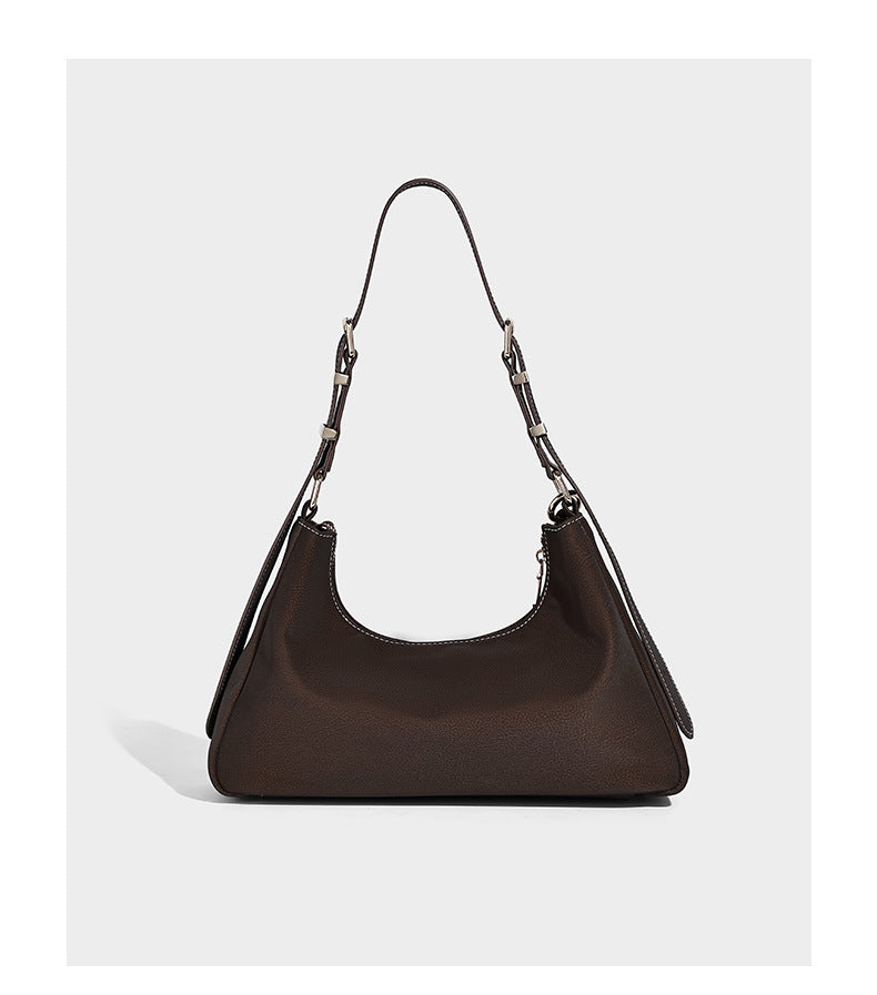 Crescent hobo shoulder bag in pebbled leather-look finish with top zipper, adjustable strap, gold-tone ring hardware, and