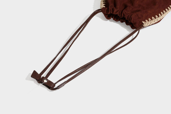 Matte suede-look drawstring bucket bag with cream braided woven edge trim and slim adjustable leather-look shoulder strap