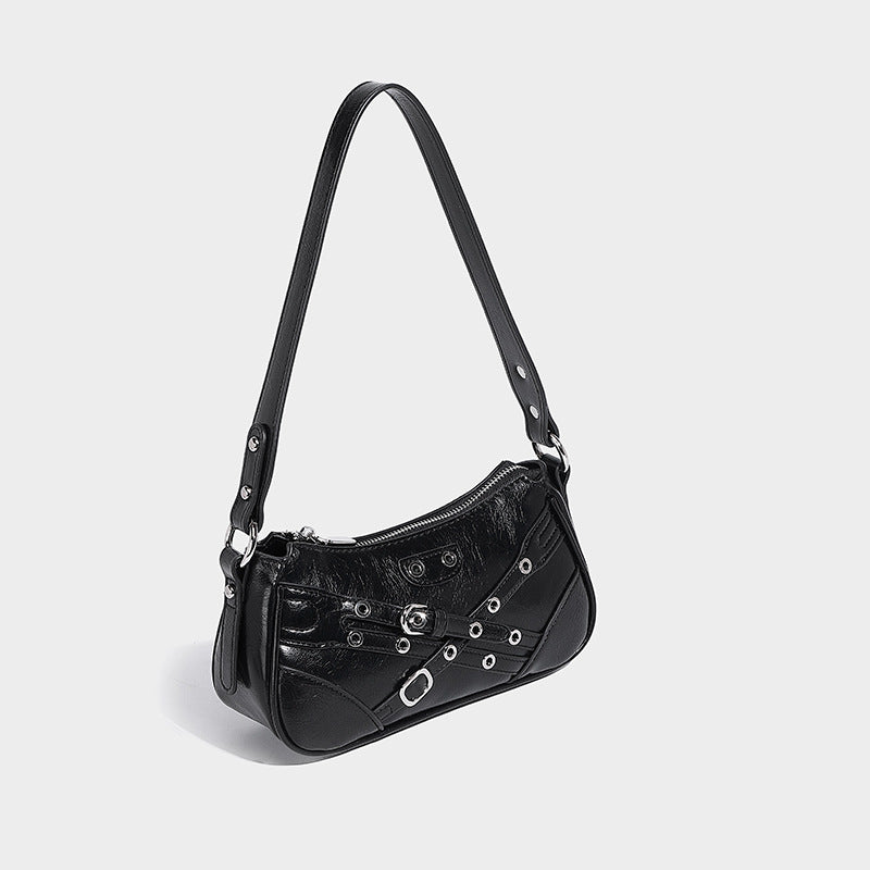 Compact moto-inspired shoulder bag with crisscross grommet strap detail, glossy textured finish, and adjustable crossbody