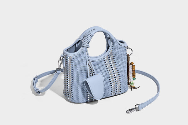 Geflochtene Bucket-Tote in Pastellblau mit geflochtenen Tragegriffen, vorderem Steckfach, Perlenanhänger und abnehmbarem Crossbody-Riemen