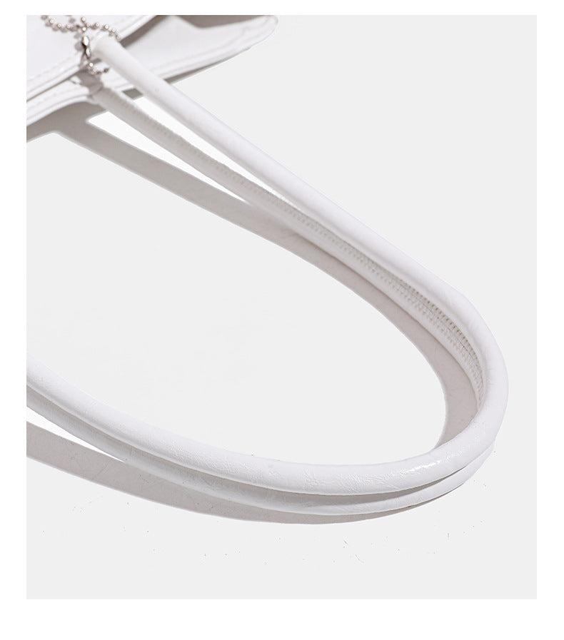 Structured rectangular crinkle leather-look tote bag with long rounded handles, zip top, and envelope-style hanging tag