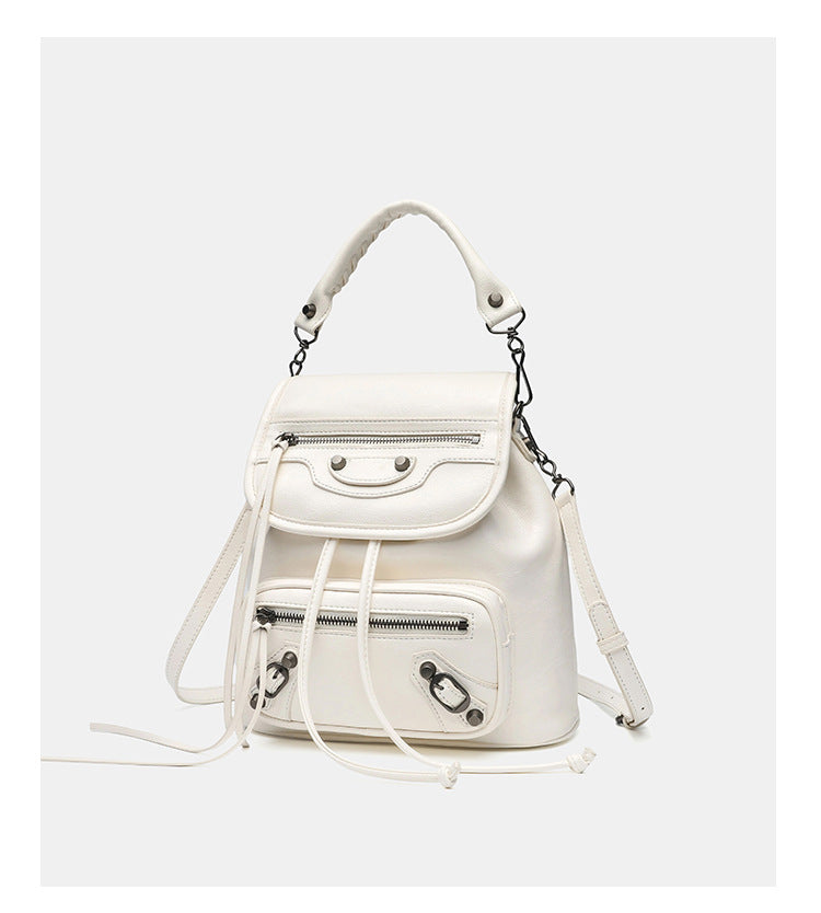 Small structured glossy leather-look convertible backpack handbag in black with flap closure, front zip pockets, metal stud