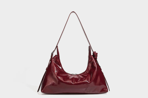 Glossy dark brown hobo shoulder bag with slim strap, front zip pocket, stud detail, and detachable leopard-print heart charm