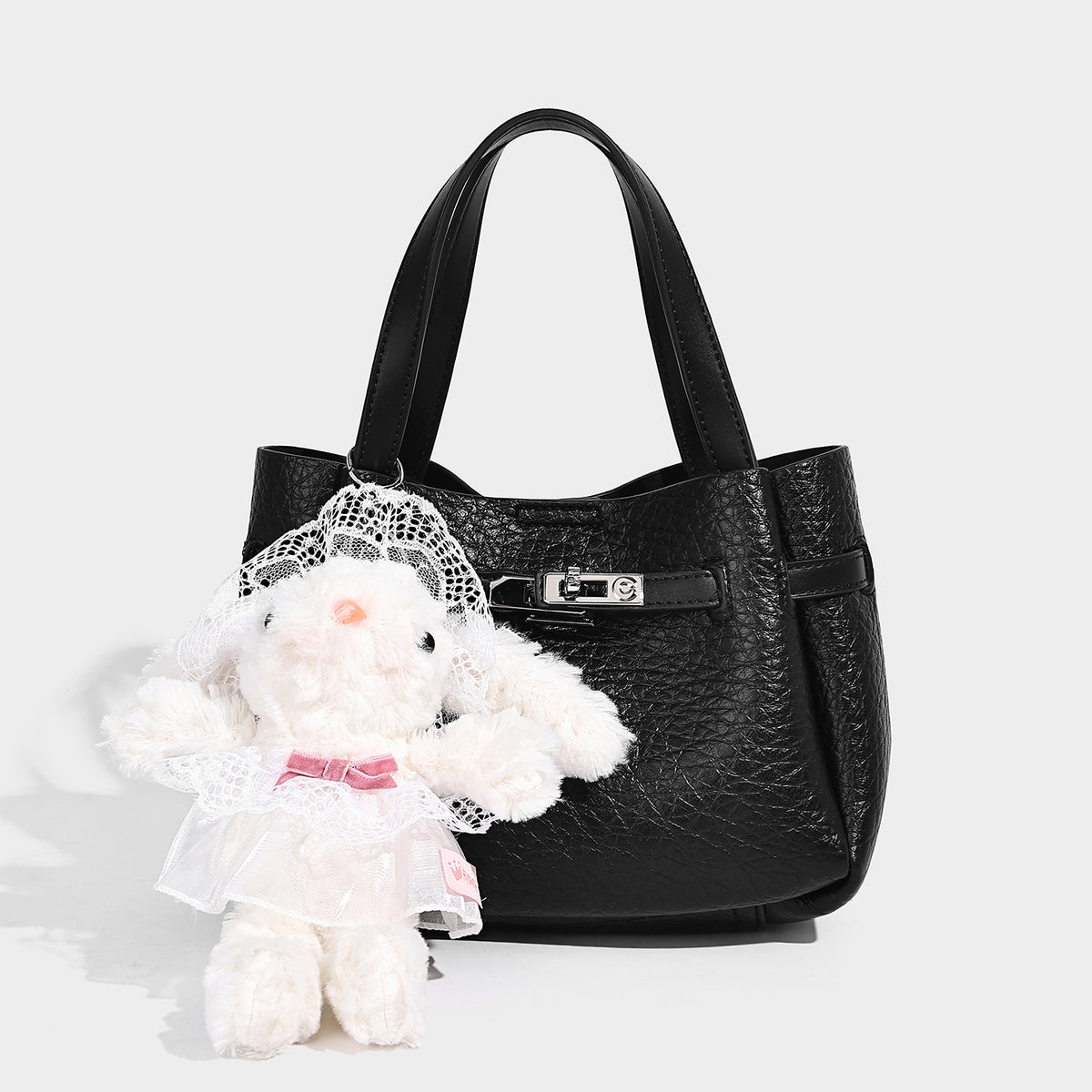 Small structured pebbled bucket tote with double top handles, silver turn-lock hardware, and detachable shoulder strap