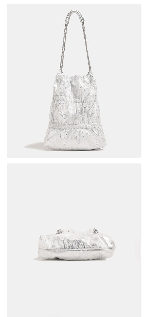 Slouchy lace-texture bucket bag with silver-tone chain strap, draped chain hardware, and shell charms, detail view 12