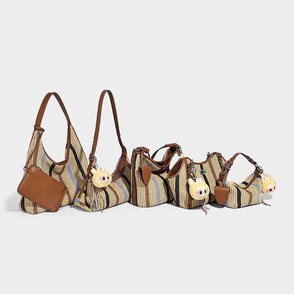 Slouchy woven straw hobo shoulder bag with beige, black, brown, and blue vertical stripes and brown leather-look trim, detail