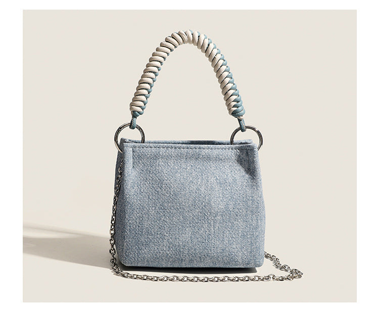 Small structured trapezoid mini bag with coiled rope top handle and silver-tone chain strap in textured fabric, detail view 9
