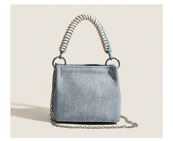 Small structured trapezoid mini bag with coiled rope top handle and silver-tone chain strap in textured fabric, detail view 9