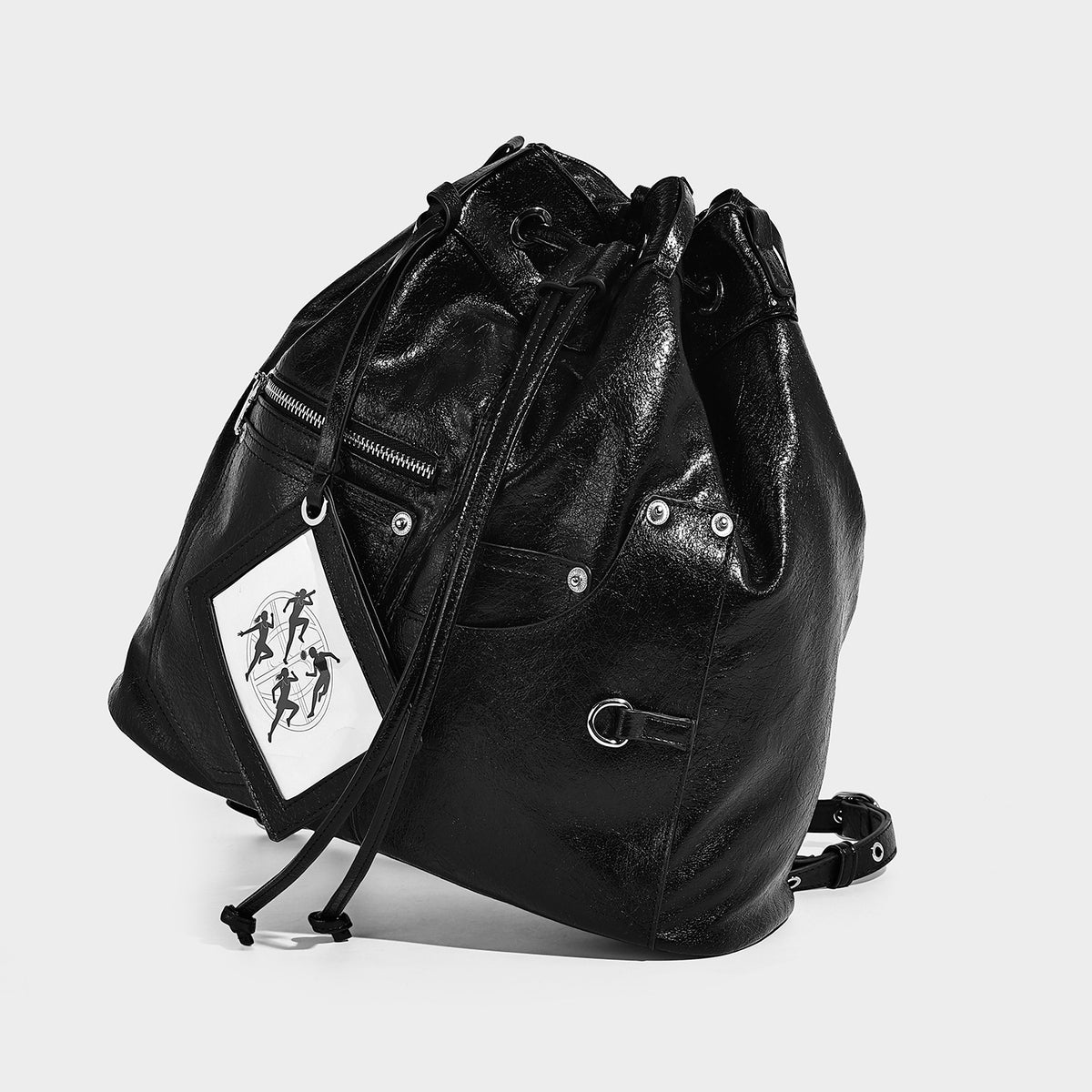 Glossy black convertible bucket backpack with silver grommet-studded straps, drawstring cinch closure, and front zip pocket