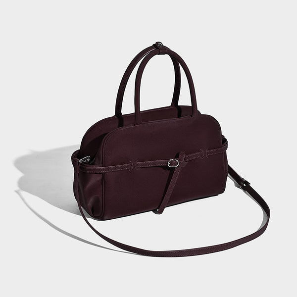Strukturierte Henkeltasche mit matter, genarbter Oberfläche, umlaufendem Riemen mit Ringbeschlägen, zwei Tragegriffen und abnehmbarem Umhängeriemen
