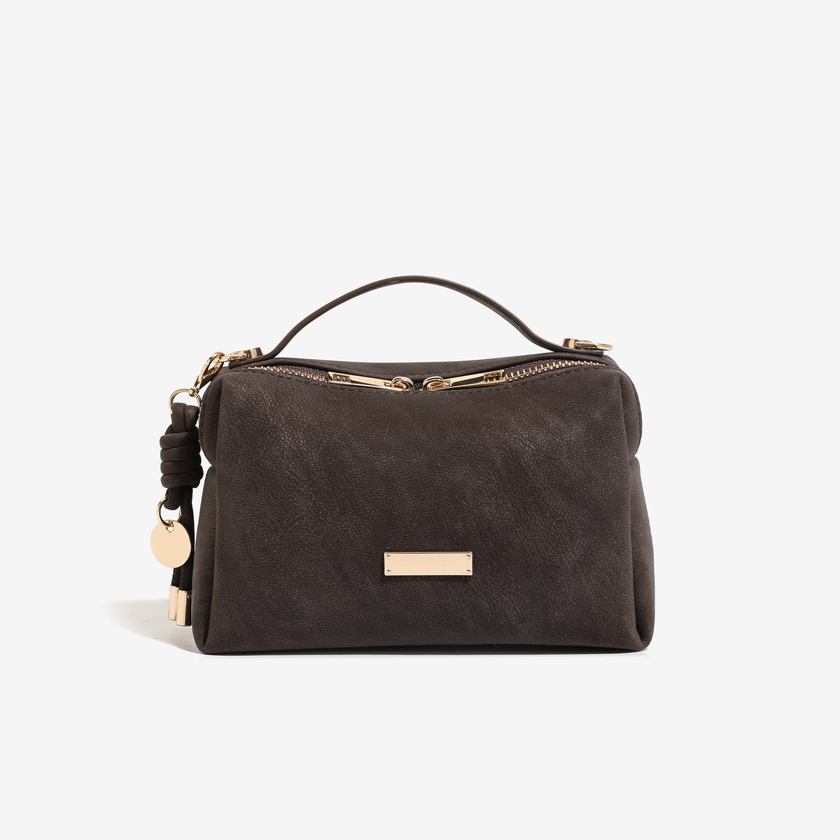 Compact boxy mini handbag with matte pebbled finish, dual top zipper, short top handle, side tassel charm, and gold-tone