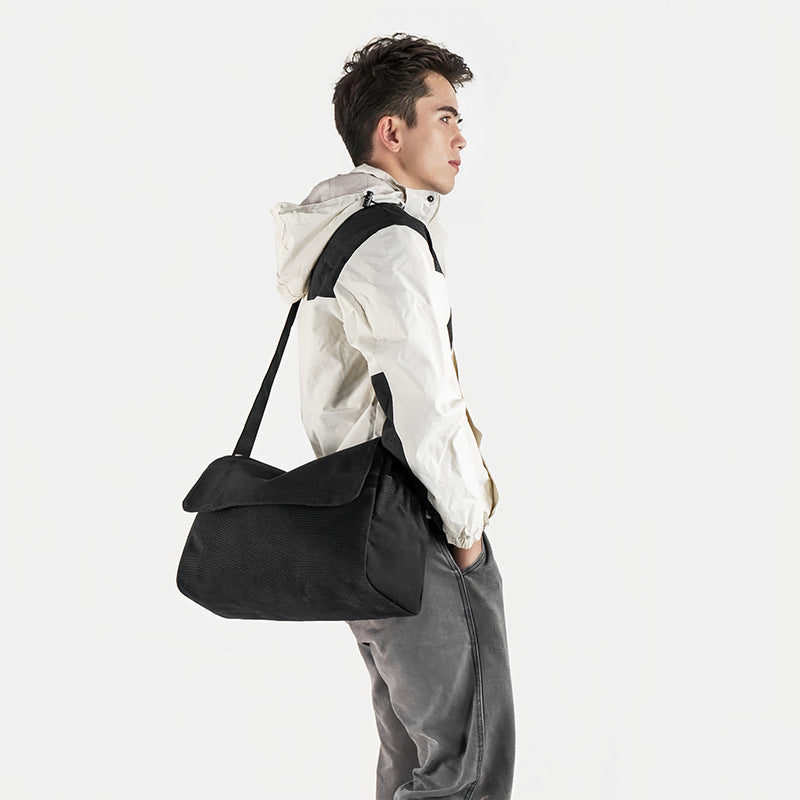 Große Messenger-Bag aus mattem schwarzem Canvas mit Frontklappe, Reißverschluss oben, elastischen Seitentaschen und verstellbarem silberfarbenem