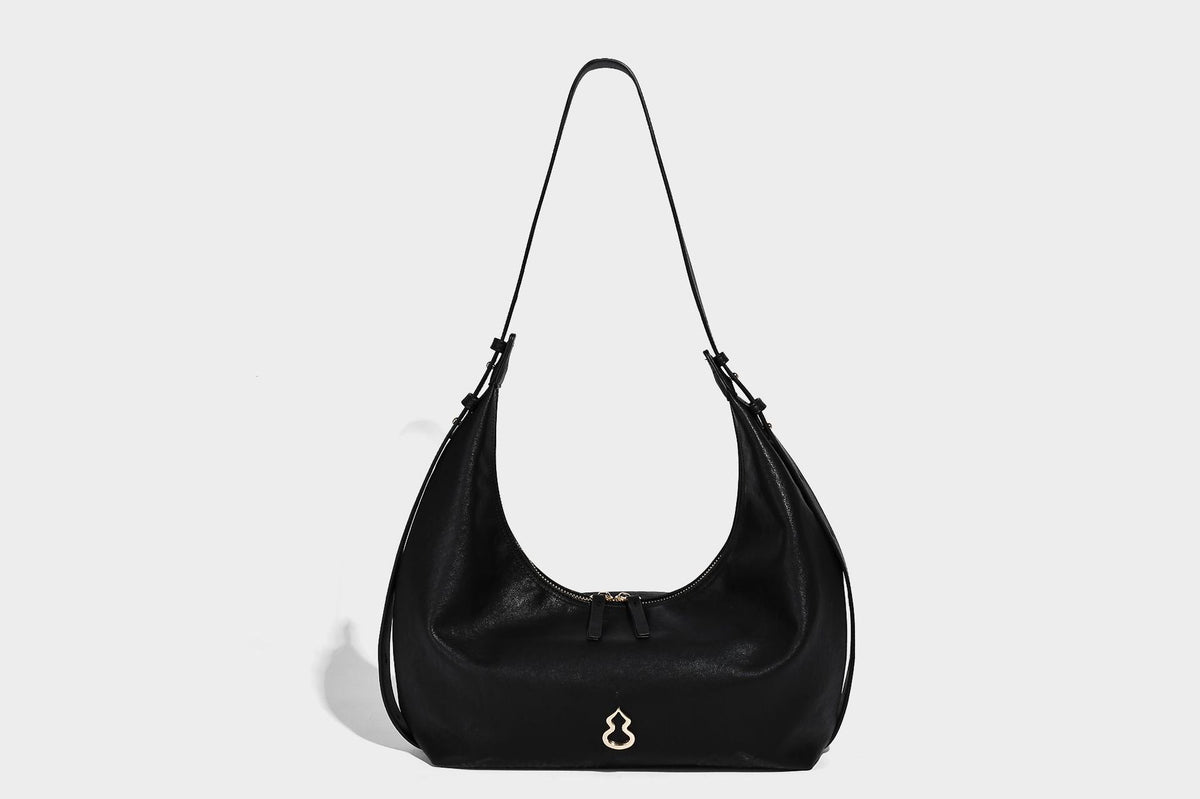 Lässig fallende, sichelförmige Hobo-Schultertasche in glatter dunkelbrauner Lederoptik mit Logo-Anhänger in Goldoptik und verstellbarem Schulterriemen