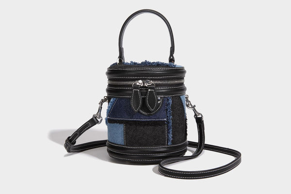 Mini cylindrical barrel bucket bag in denim patchwork with frayed edges, smooth leather-look trim, zip-around top closure