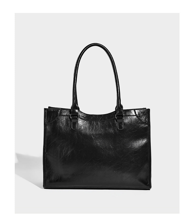 Large structured leather-look tote bag with front zip pocket, moto hardware accents, and long double shoulder straps, detail