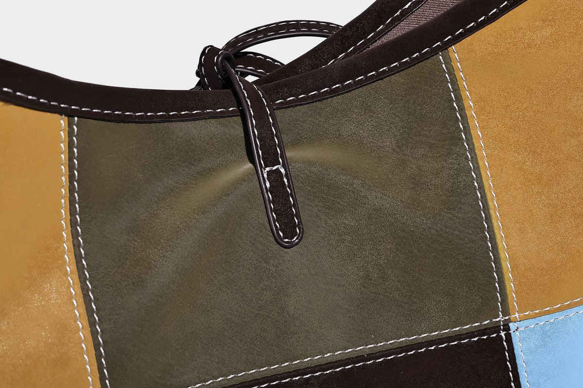 Patchwork bucket tote shoulder bag with tan, dark brown, olive, red, and sky blue color-block panels, white contrast, detail