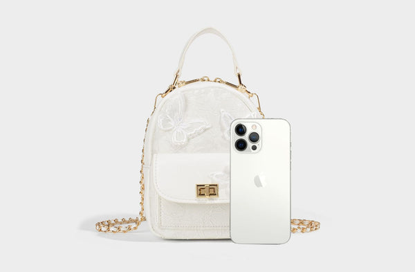 Structured mini backpack handbag with butterfly embroidery, gold-tone chain strap, and turn-lock front flap pocket, detail
