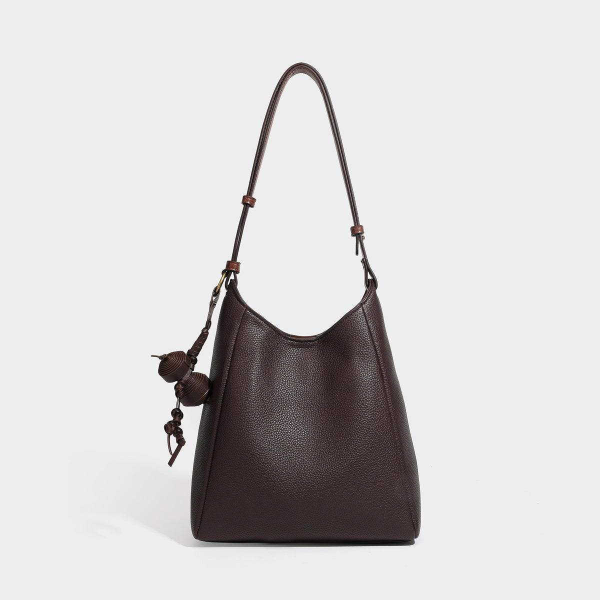 Dunkel espressofarbene Hobo-Schultertasche in genarbter Optik mit warm cognacfarbenem Besatz, verstellbarem schmalem Riemen, goldfarbenen Ringbeschlägen und geknotetem