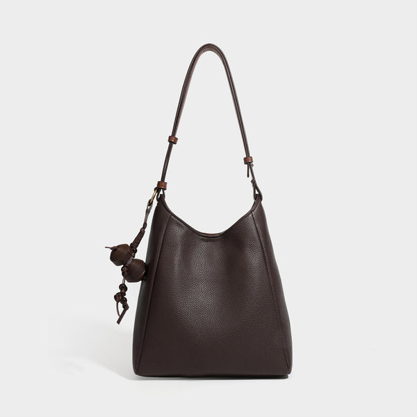 Dunkel espressofarbene Hobo-Schultertasche in genarbter Optik mit warm cognacfarbenem Besatz, verstellbarem schmalem Riemen, goldfarbenen Ringbeschlägen und geknotetem