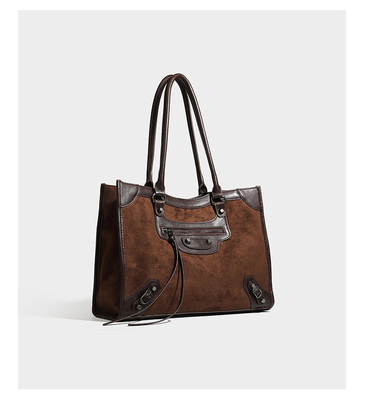 Large structured tote bag with matte suede-like body, smooth leather-look trim, front zip pocket, stud hardware, and