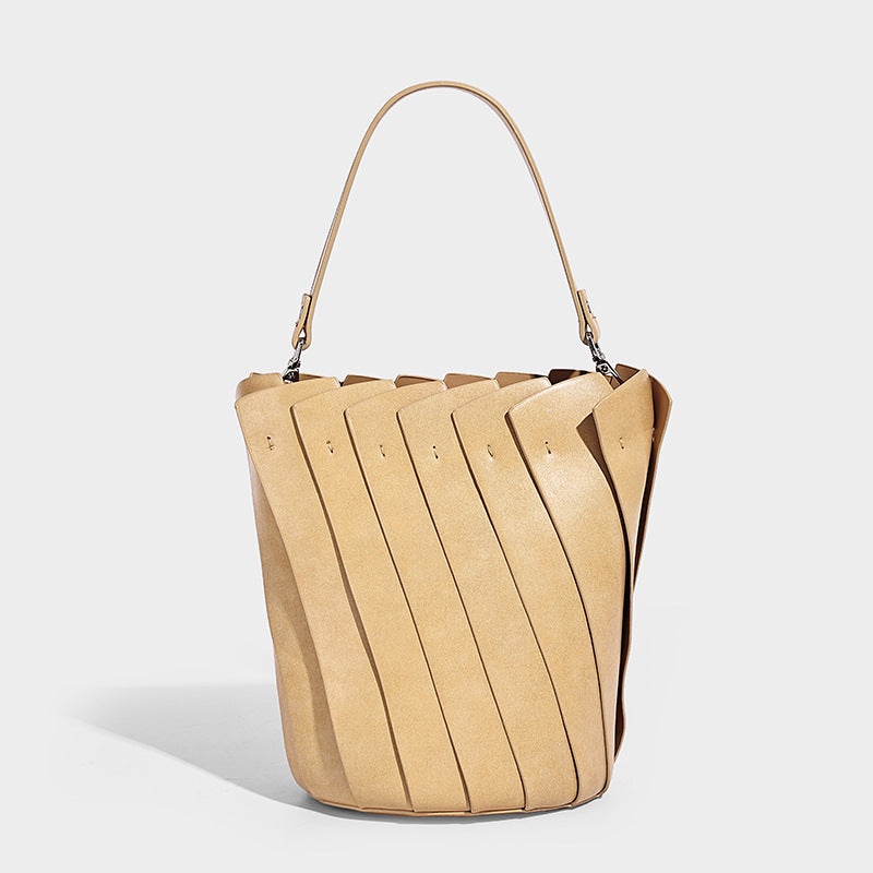 Structured pleated-panel bucket bag with curved top handle and detachable adjustable shoulder strap in smooth matte, detail