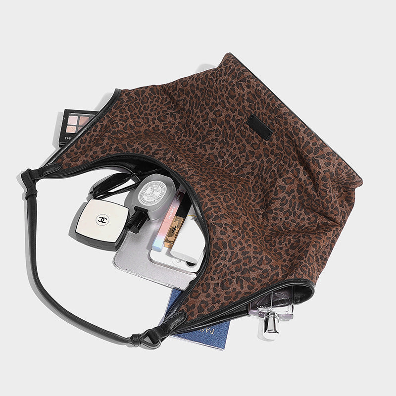 Slouchy brown leopard jacquard hobo tote bag with black leather-look trim and single shoulder strap, shown with black, detail