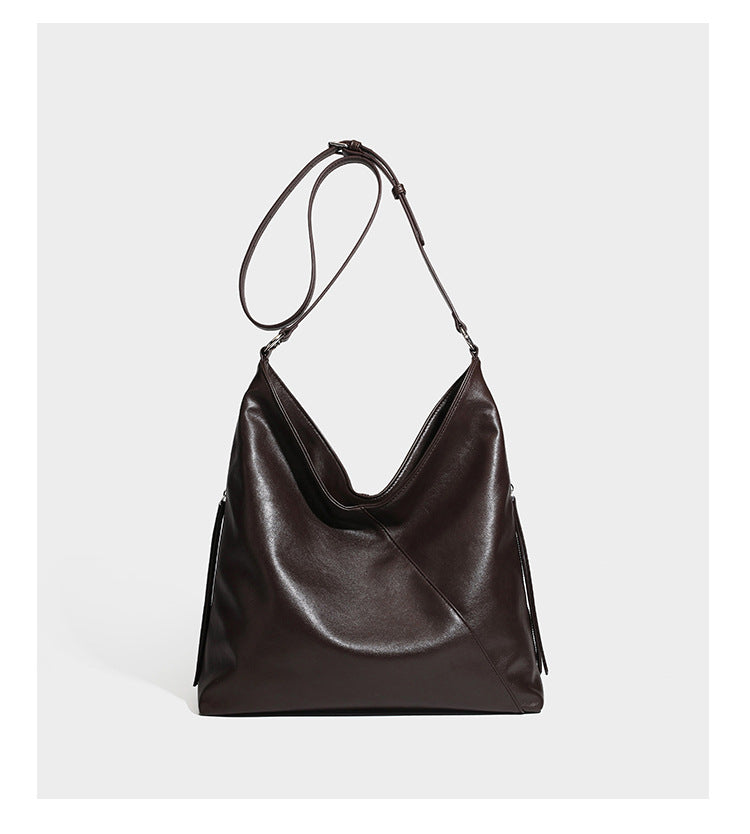 Large slouchy hobo shoulder bag with braided top handle, smooth glossy leather-look finish, and silver-tone ring hardware
