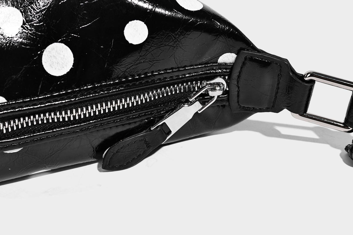 Kompakte glänzende Hobo-Schultertasche in Schwarz mit weißen Punkten, Reißverschluss, Beschlägen in Gunmetal und befestigtem Überschlag vorne