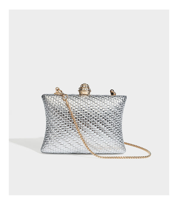 Small structured rectangular metallic woven-texture clutch bag with jeweled knob clasp and gold-tone chain strap, detail view