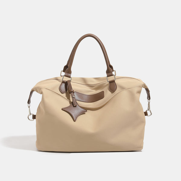 Large slouchy nylon tote bag with brown leather-look handles, double-pull zip closure, and star charm detail, front view