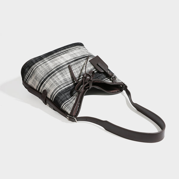 Schwarz-weiß karierte Hobo-Schultertasche aus gewebtem Material mit dunkelbrauner Einfassung in Lederoptik, Kordelzugverschluss und langem, verstellbarem