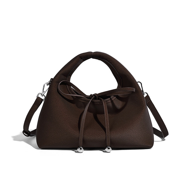 Pebbled matte trapezoid top-handle bag with drawstring bow closure, bead-tipped cords, silver-tone hardware, and detachable
