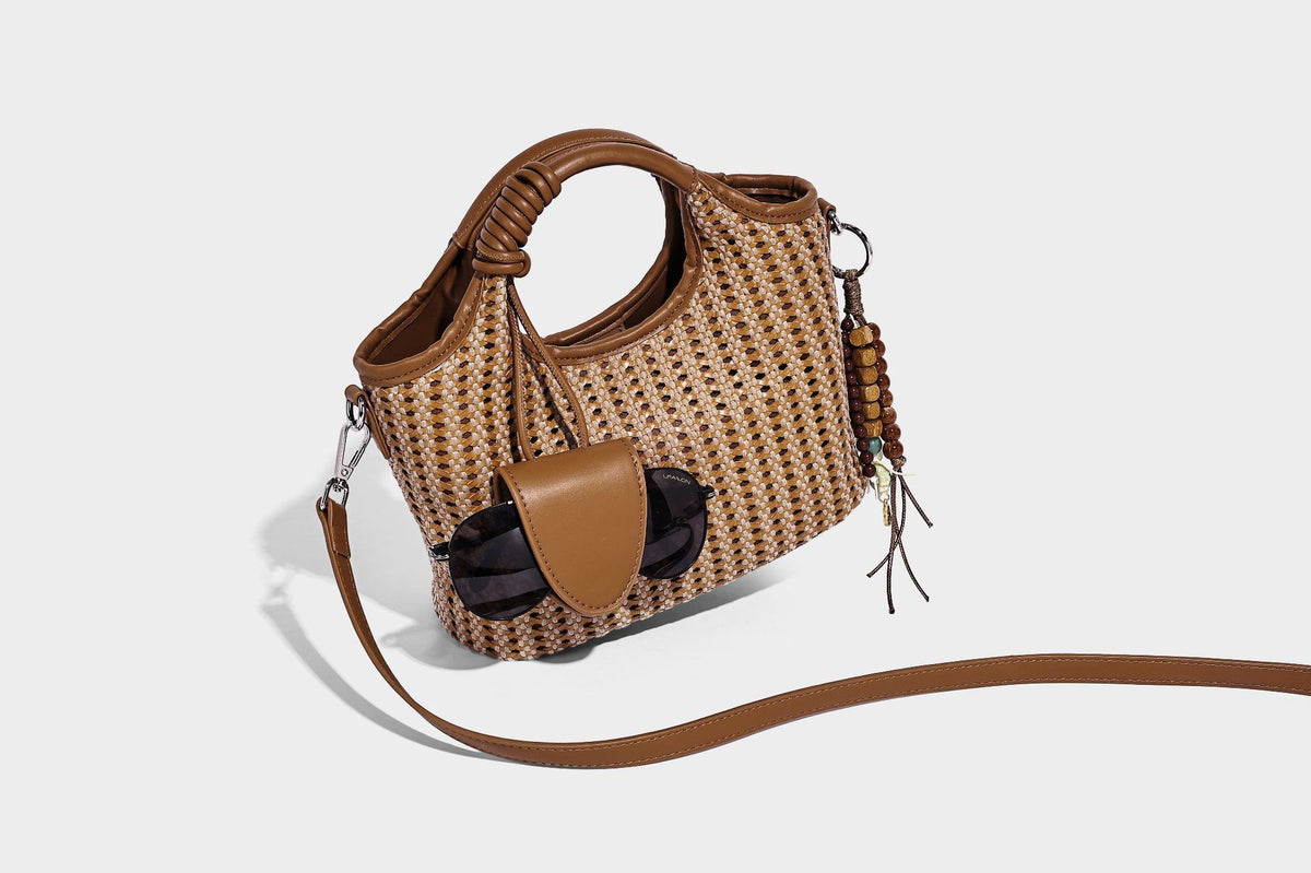 Small structured woven tote crossbody bag with ring top handle, leather-look brown trim, front patch pocket, and detachable