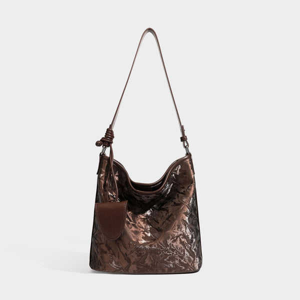 Große Hobo-Schultertasche mit Knitterglanz in tiefem Braun, schmalem verstellbarem Riemen, geknoteten Beschlägen und angesetztem seitlichem Überschlag