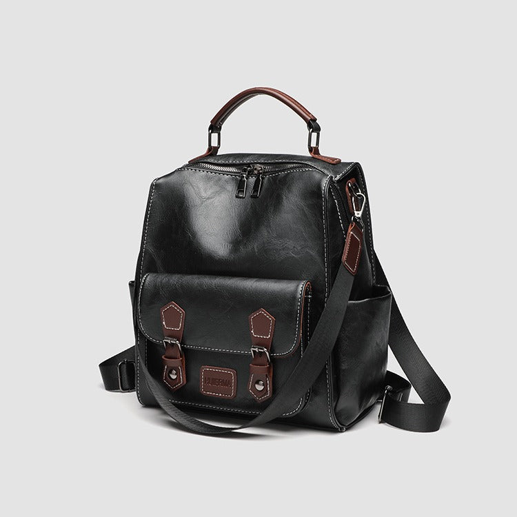 Structured black leather-look convertible backpack handbag with brown contrast trim, buckle front pocket, double-zip top