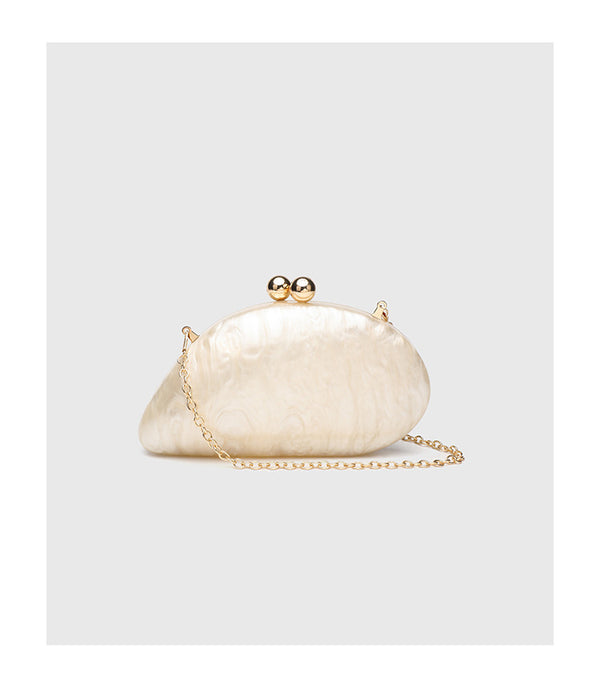 Ovale Hartschalen-Clutch in marmorierter Perlmuttoptik mit Verschluss aus zwei goldfarbenen Kugeln und goldfarbener Kettenriemen, Detailansicht