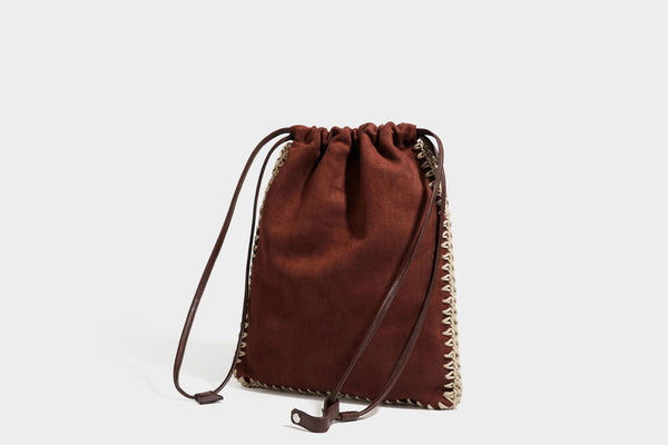 Matte suede-look drawstring bucket bag with cream braided woven edge trim and slim adjustable leather-look shoulder strap
