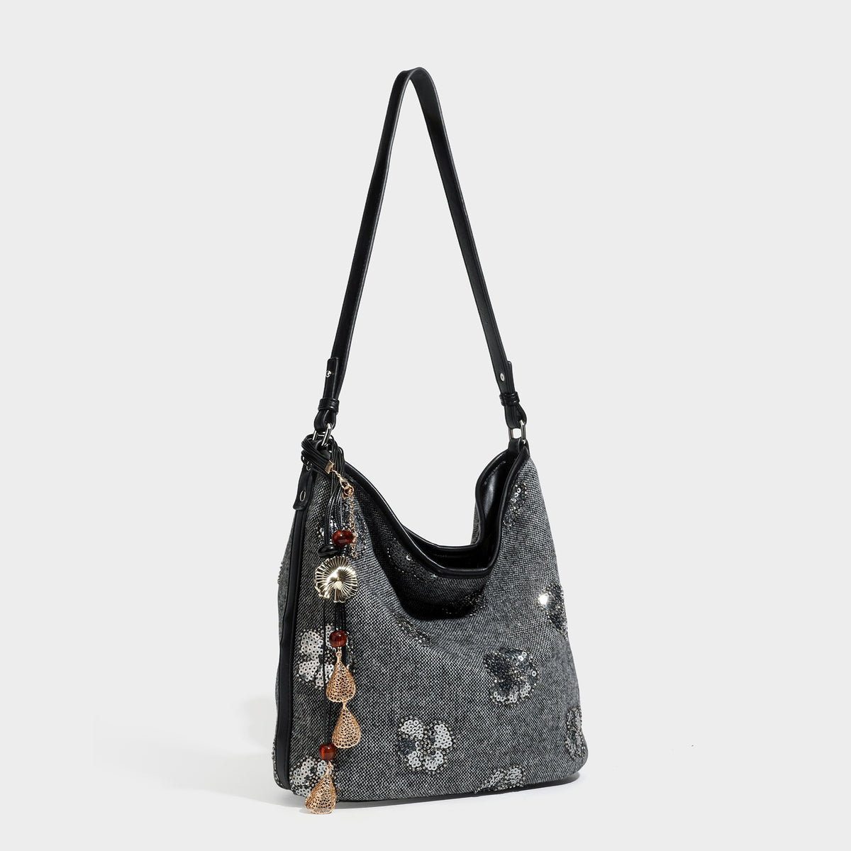 Slouchy hobo shoulder bag in charcoal woven fabric with silver sequin floral embroidery, black leather-look trim, and long
