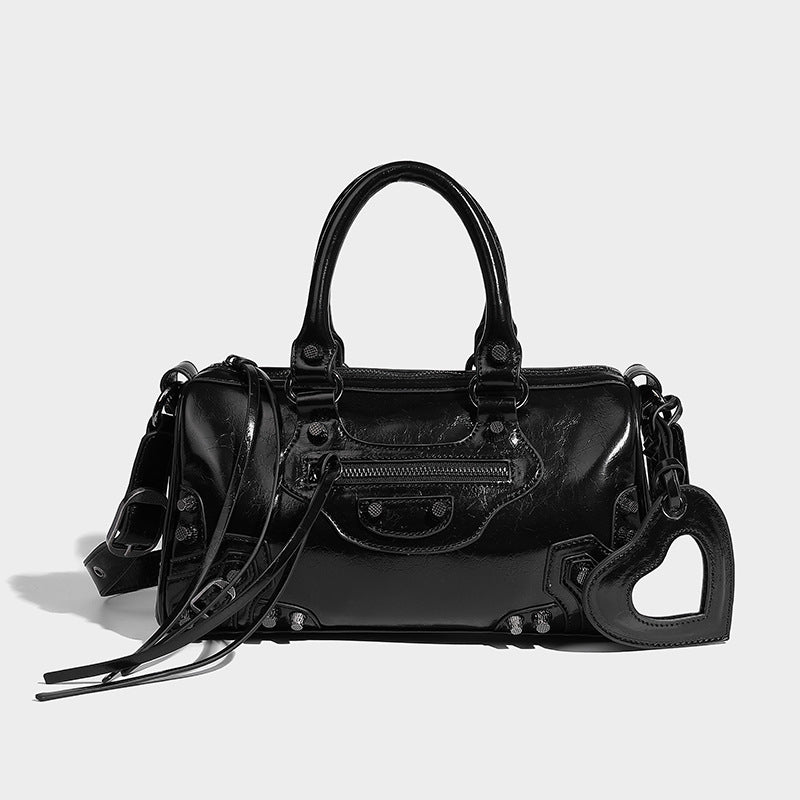 Glossy studded mini satchel bag with braided top handles, front zip pocket, heart charm, and detachable crossbody strap