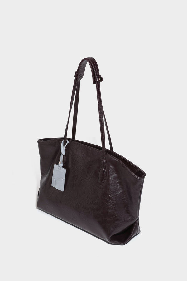 Übergroße, lässig fallende Tote-Bag aus glänzendem, geknittertem Lederimitat in dunklem Burgunderrot mit zwei langen Schulterriemen und kontrastierendem