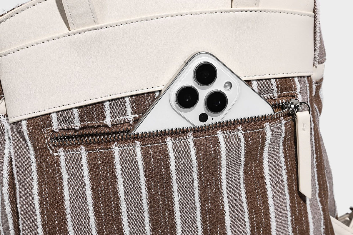 Small structured striped fabric backpack handbag with cream leather-look trim, top handle, and silver-tone hardware, detail