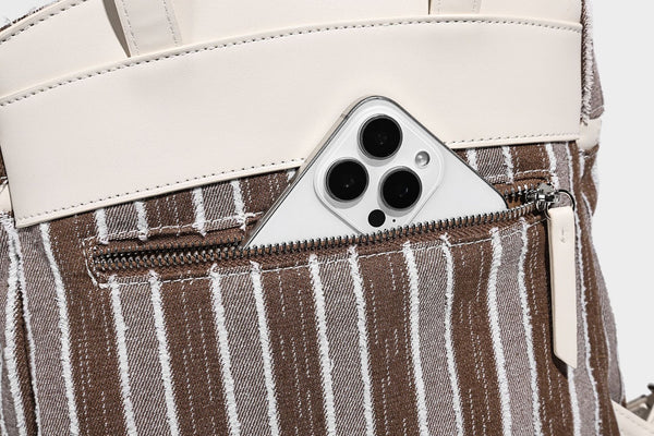 Small structured striped fabric backpack handbag with cream leather-look trim, top handle, and silver-tone hardware, detail