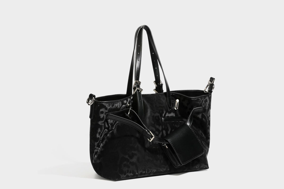 Glossy leopard-print tote bag with leather-look dark trim, dual top handles, detachable shoulder strap, and attached front