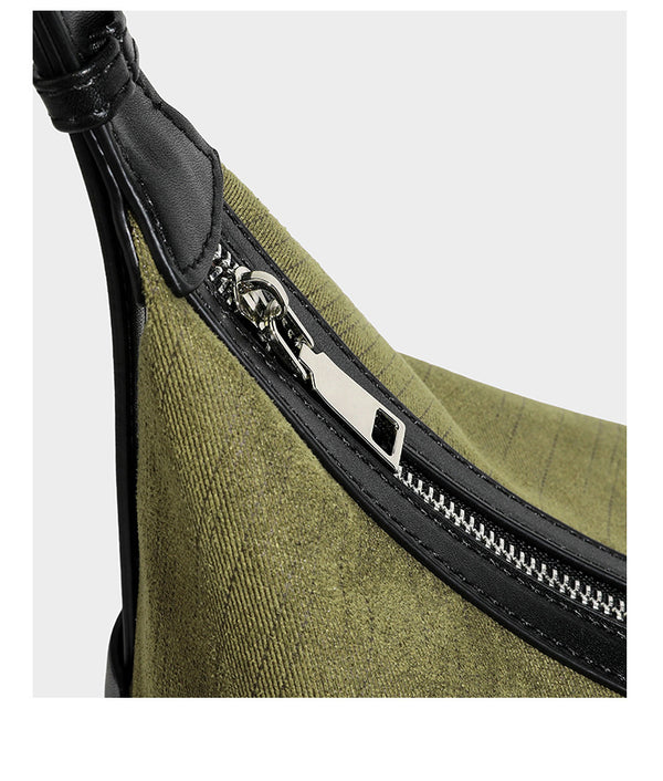 Slouchy olive green canvas hobo shoulder bag with black leather-look trim, zip-top closure, and adjustable strap, detail view